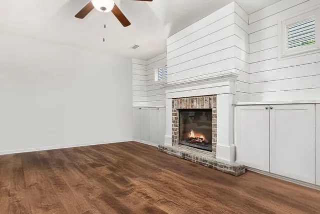 an empty room with a fireplace and wooden floor