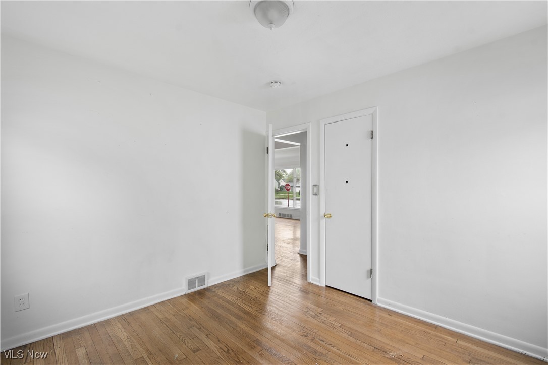 1193 South Green Road Cleveland, OH 44121 - Photo 15 of 28 Unfurnished room featuring visible vents, wood-type flooring, and baseboards