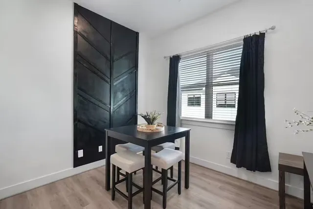 a room that has a table and a chair with wooden floor