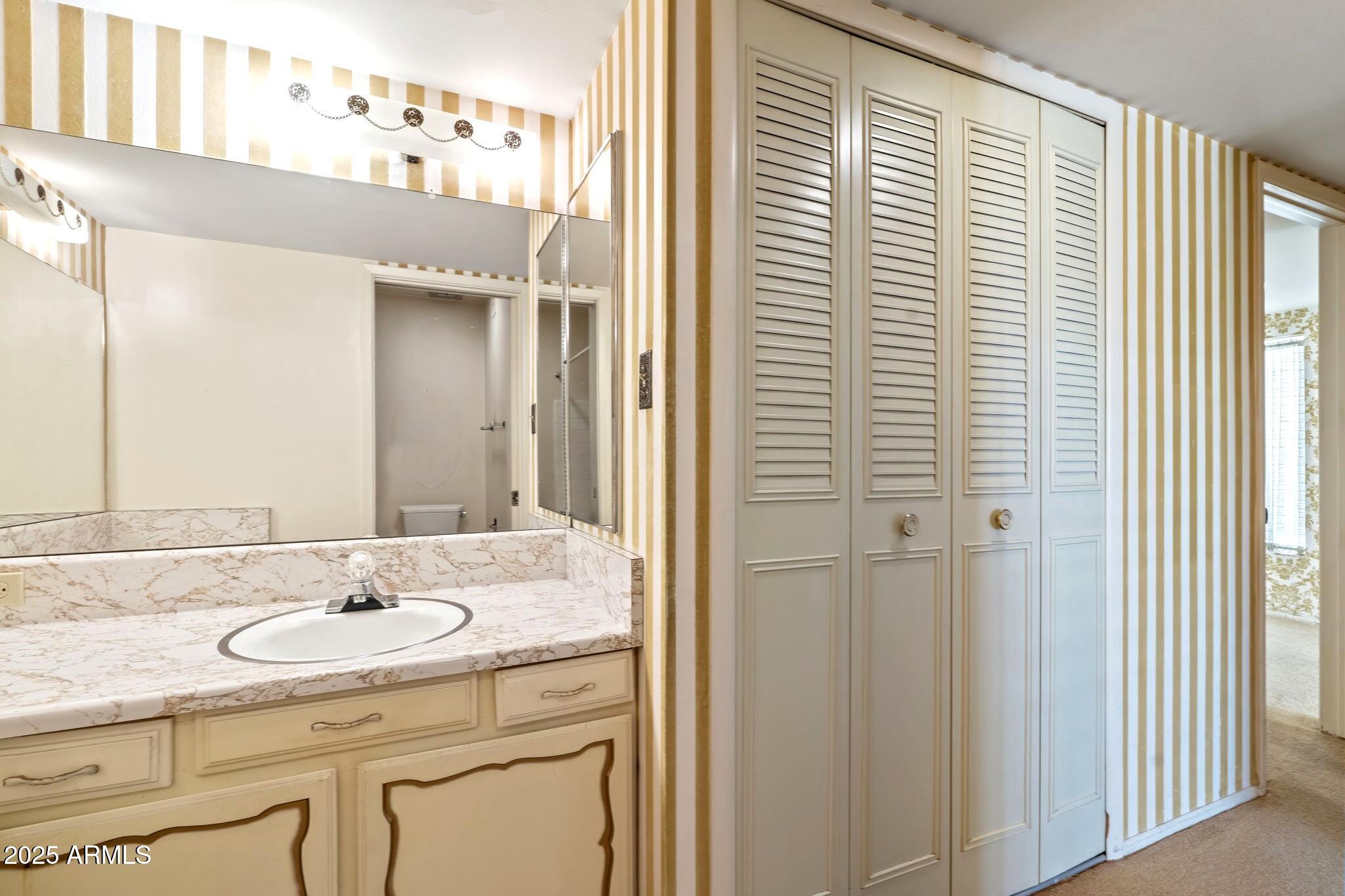 7706 East Chaparral Road Scottsdale, AZ 85250 - Photo 14 of 33 a bathroom with a granite countertop sink and a mirror