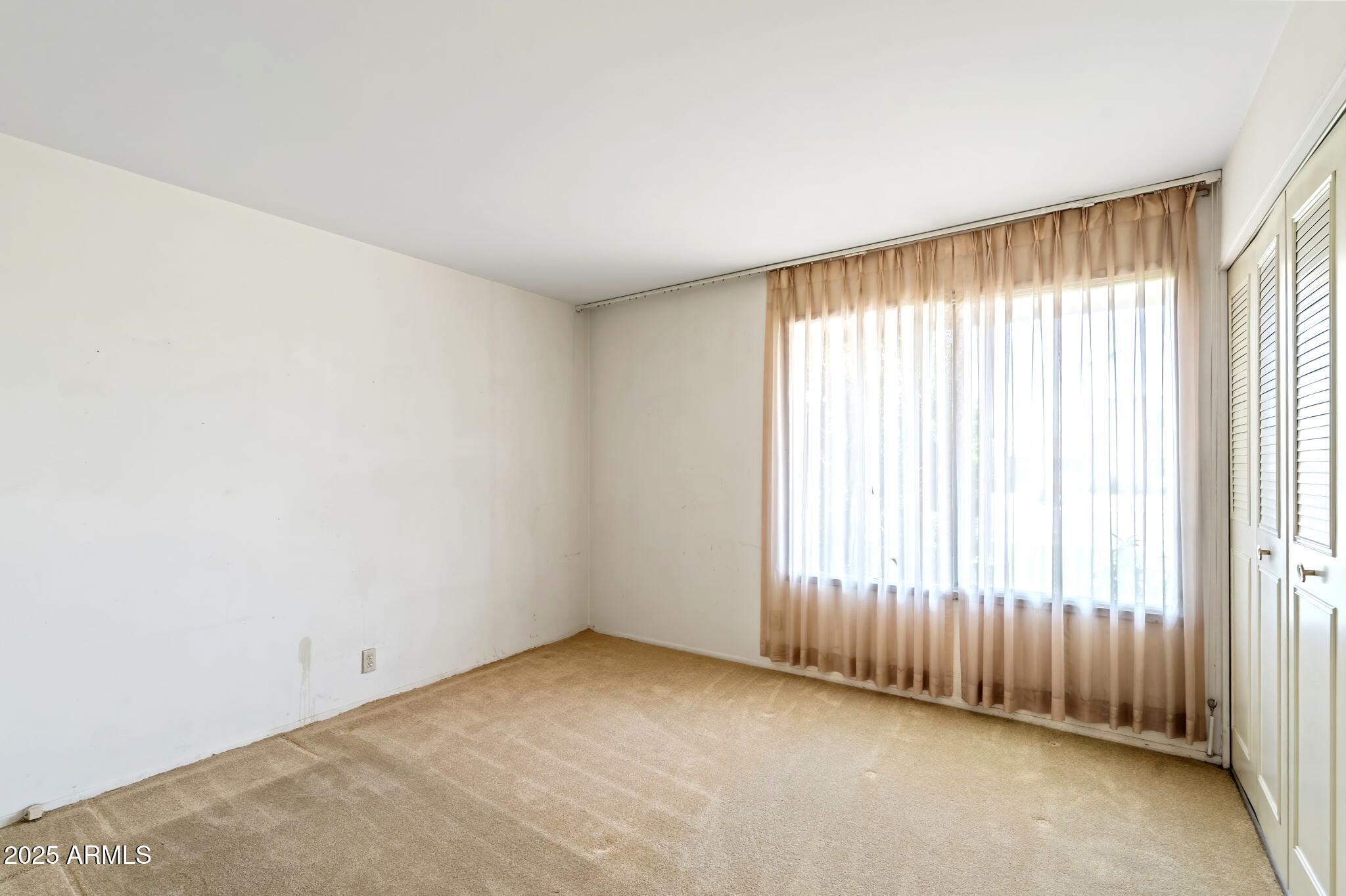 7706 East Chaparral Road Scottsdale, AZ 85250 - Photo 17 of 33 an empty room with a window