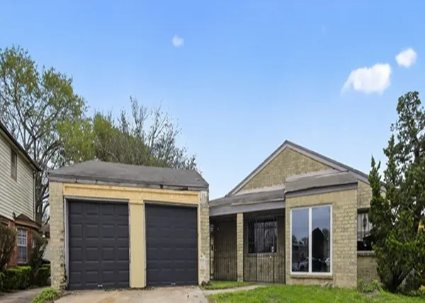 a view of a brick house with a large windows and a large tree with large windows