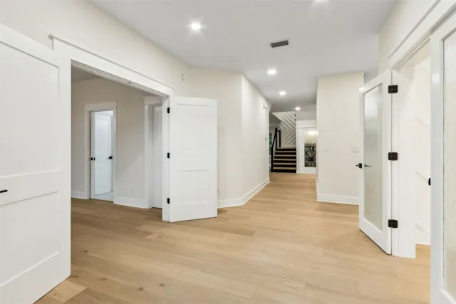 a view of an empty room with stairs and windows
