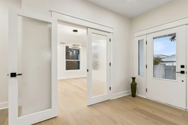 a view of an empty room with a window and kitchen