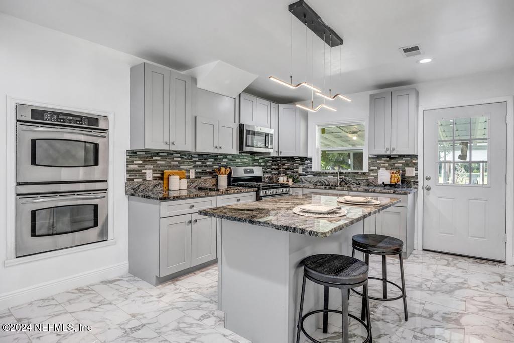 9750 Hood Road Jacksonville, FL 32257 - Photo 16 of 53 a kitchen with granite countertop a stove a sink and a refrigerator