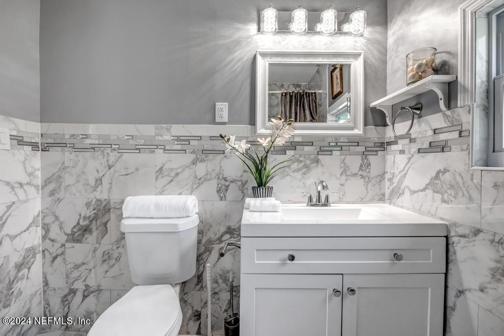 9750 Hood Road Jacksonville, FL 32257 - Photo 21 of 53 a bathroom with a sink a toilet and a mirror