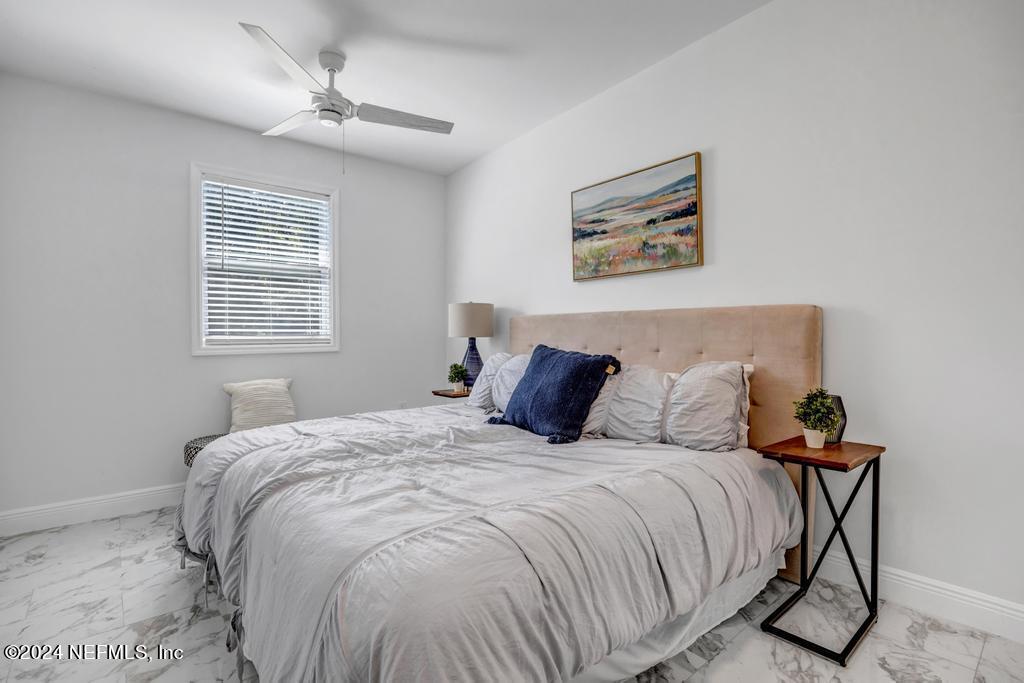 9750 Hood Road Jacksonville, FL 32257 - Photo 24 of 53 a bed sitting in a bedroom next to a window