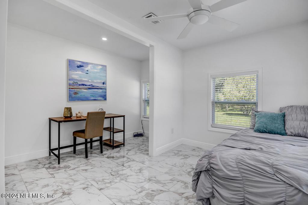 9750 Hood Road Jacksonville, FL 32257 - Photo 27 of 53 a bedroom with a bed a table and a window