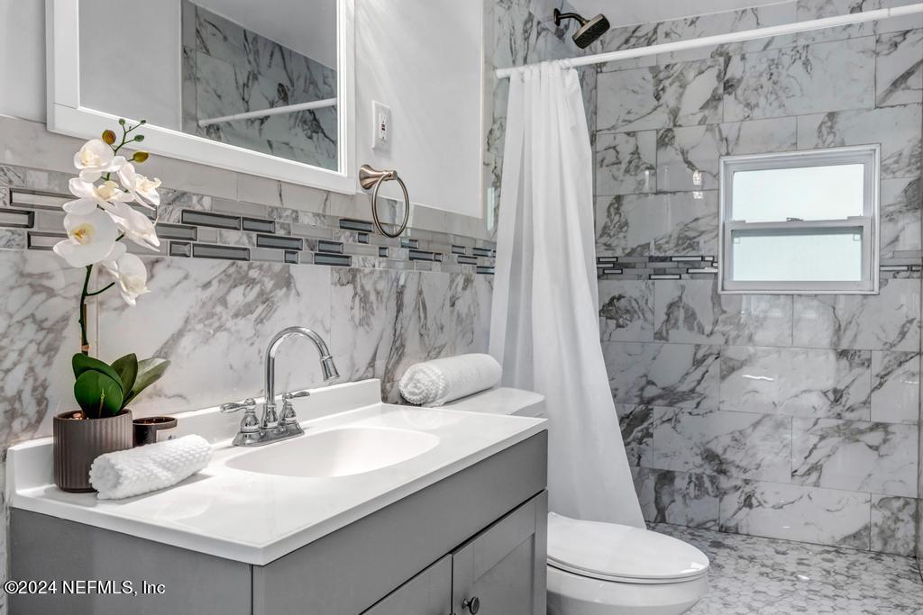 9750 Hood Road Jacksonville, FL 32257 - Photo 30 of 53 a bathroom with a sink a toilet and shower