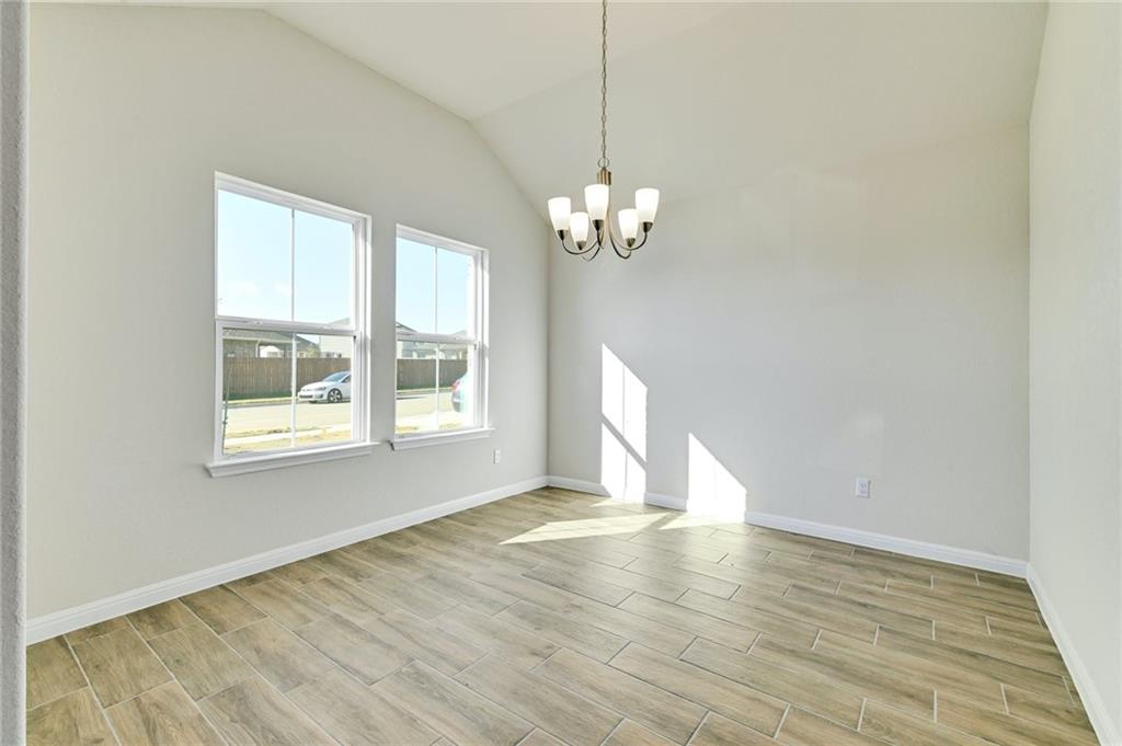 208 Evening Star Lane Georgetown, TX 78628 - Photo 12 of 26 a view of an empty room with wooden floor and a window