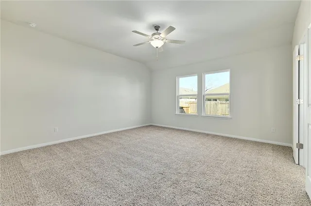 an empty room with a window and a ceiling fan