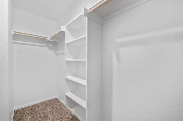 a view of walk in closet with empty racks