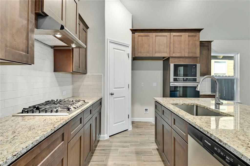 208 Evening Star Lane Georgetown, TX 78628 - Photo 5 of 26 a kitchen with granite countertop a sink stove and cabinets