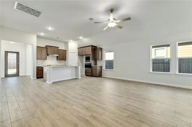 a view of kitchen with cabinets appliances and wooden floor