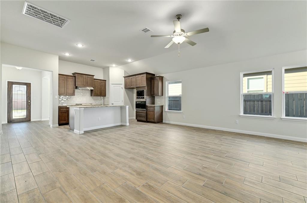 208 Evening Star Lane Georgetown, TX 78628 - Photo 7 of 26 a view of a kitchen with a sink cabinet a refrigerator and windows
