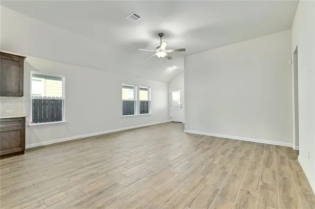a view of a kitchen with a sink cabinet a refrigerator and windows