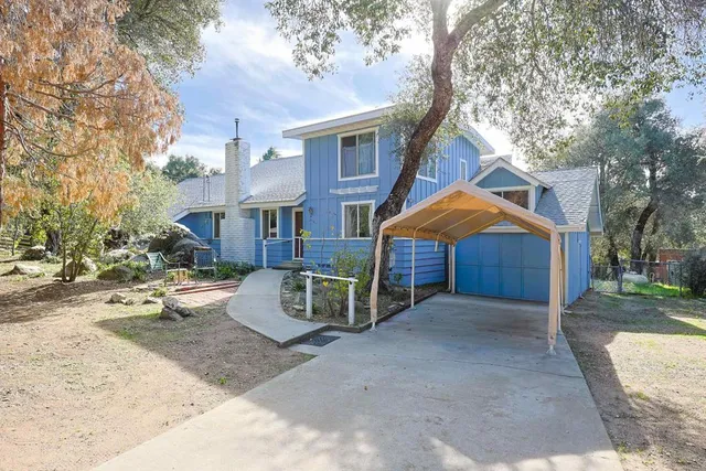 a view of a house with a yard and wooden fence