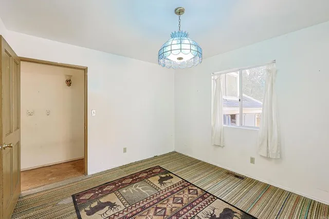 a living room with furniture a chandelier and a window