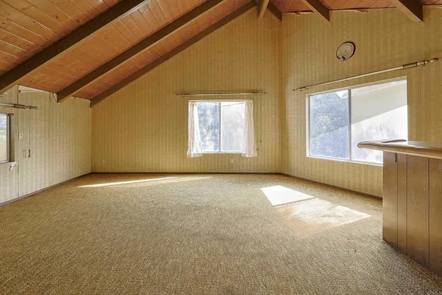 a view of empty room with wooden floor and windows