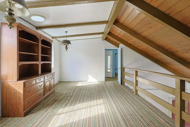 a view of a balcony with a large window and wooden fence