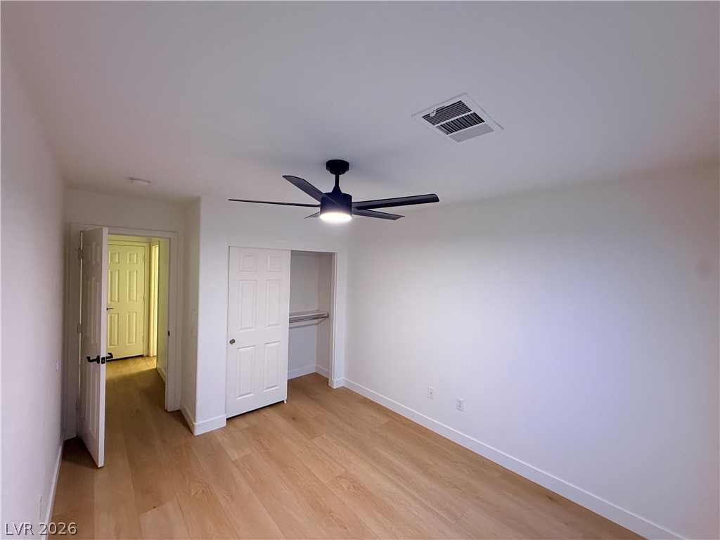 2122 Hidden Ranch Terrace Henderson, NV 89052 - Photo 12 of 20 Hardwood flooring extends throughout this well-lit bedroom, featuring a convenient sliding door closet.