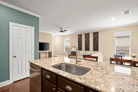 a kitchen with granite countertop a sink and white cabinets