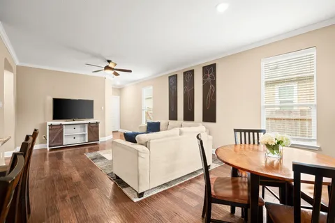 a living room with furniture a flat screen tv and a large window