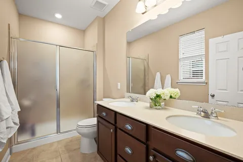 a bathroom with a double vanity sink toilet and a mirror