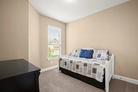 a bedroom with a bed in it and next to a window