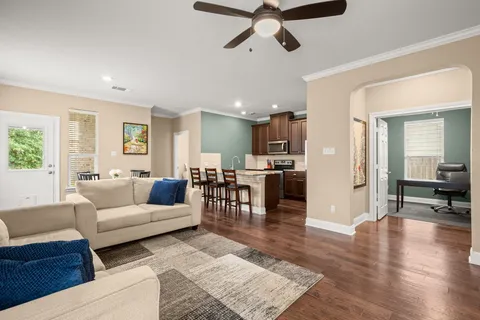 a living room with furniture and a wooden floor