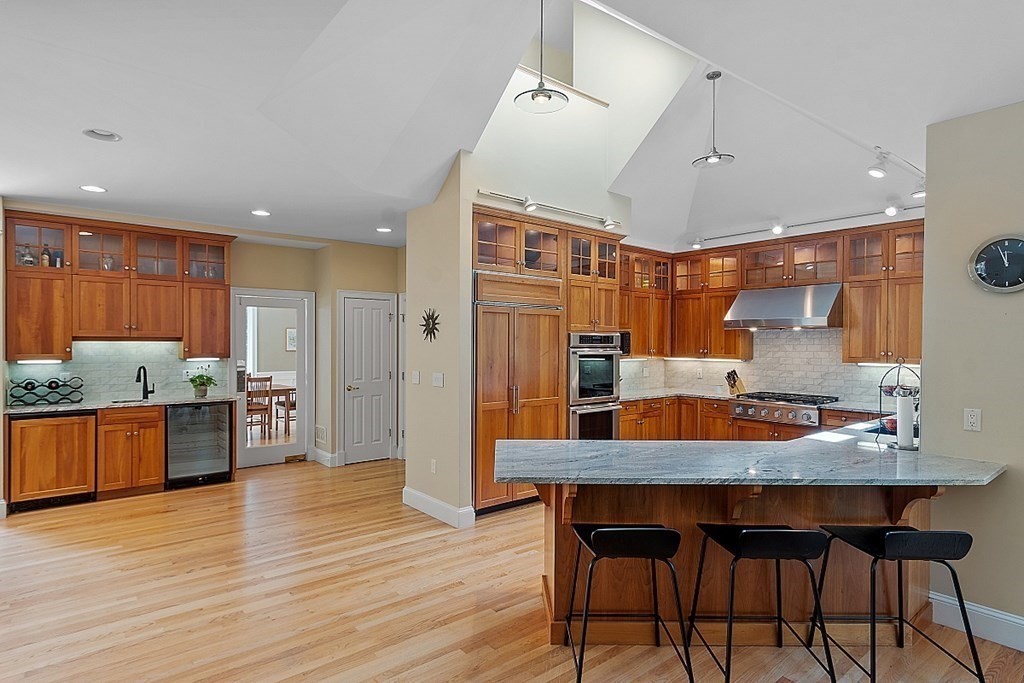 166 Tower Road Lincoln, MA 01773 - Photo 7 of 39 a kitchen with granite countertop a table chairs stainless steel appliances and wooden floor