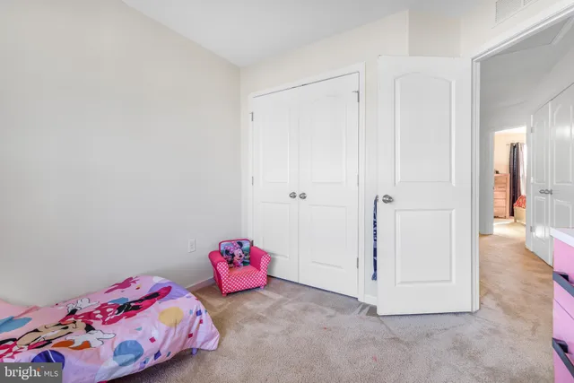 a bedroom with a bed chair and a large window