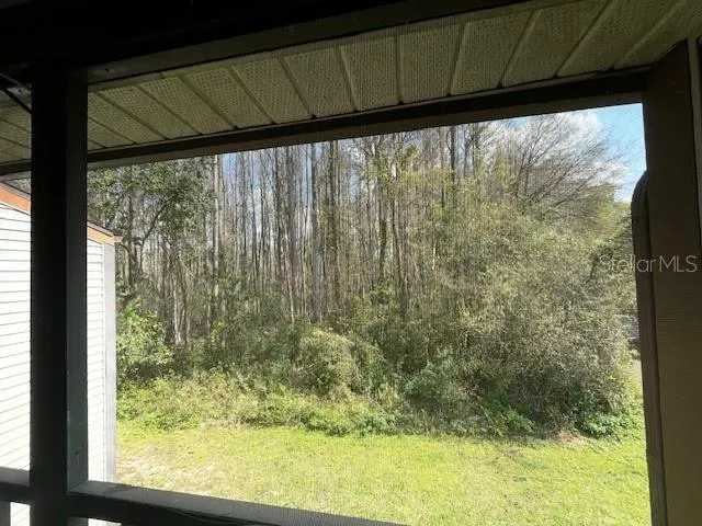 a view of a room with a large window with outdoor space
