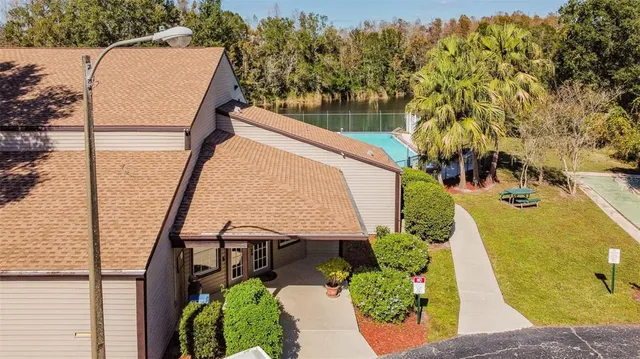an aerial view of residential house with outdoor space and trees all around