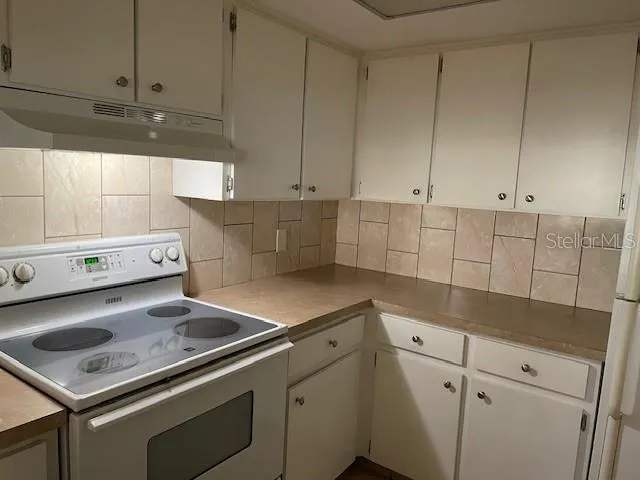 a kitchen with white cabinets and white appliances