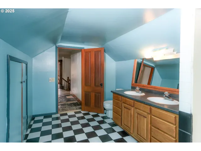 a view of a house with a barbeque and wooden fence