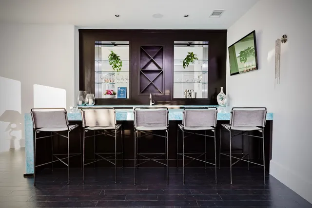 a kitchen with stainless steel appliances kitchen island granite countertop a stove top oven a sink a dining table and chairs with wooden floor