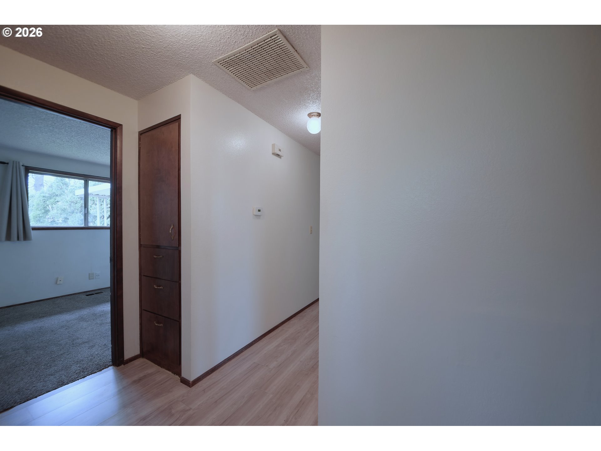 1798 Gilham Road Eugene, OR 97401 - Photo 13 of 30 a view of an empty room with wooden floor and a window