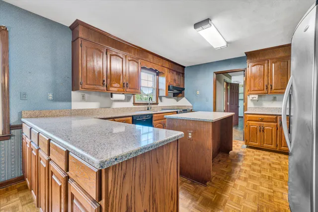 a kitchen with stainless steel appliances granite countertop wooden cabinets a granite counter tops and a sink