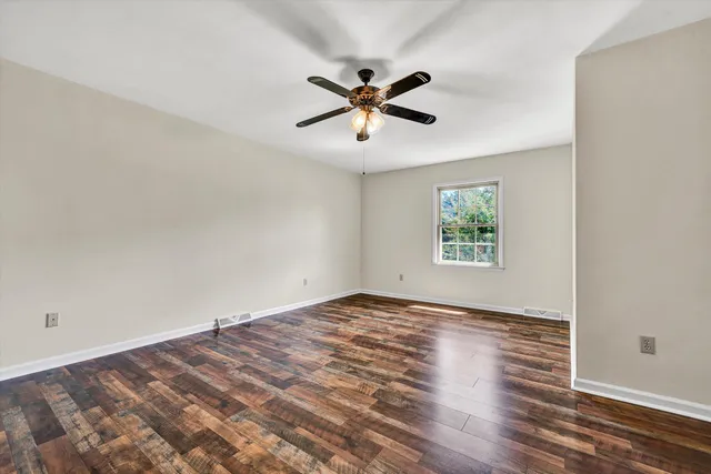 a view of a room with wooden floor and white walls