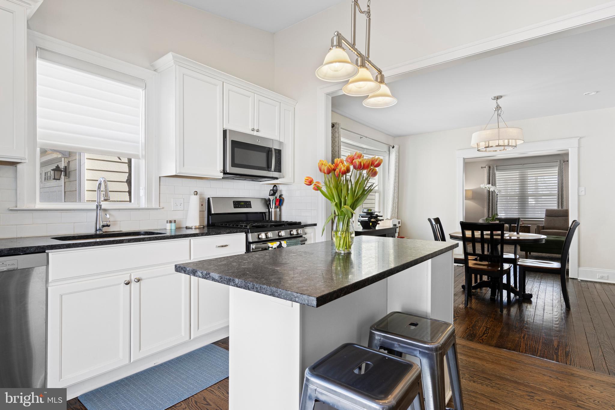 657 West End Walk Media, PA 19063 - Photo 9 of 26 a kitchen with stainless steel appliances granite countertop a stove top oven a sink a dining table and chairs with wooden floor