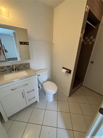 a bathroom with a granite countertop sink toilet and mirror