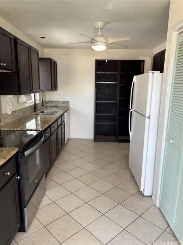 a kitchen with granite countertop a refrigerator and a sink