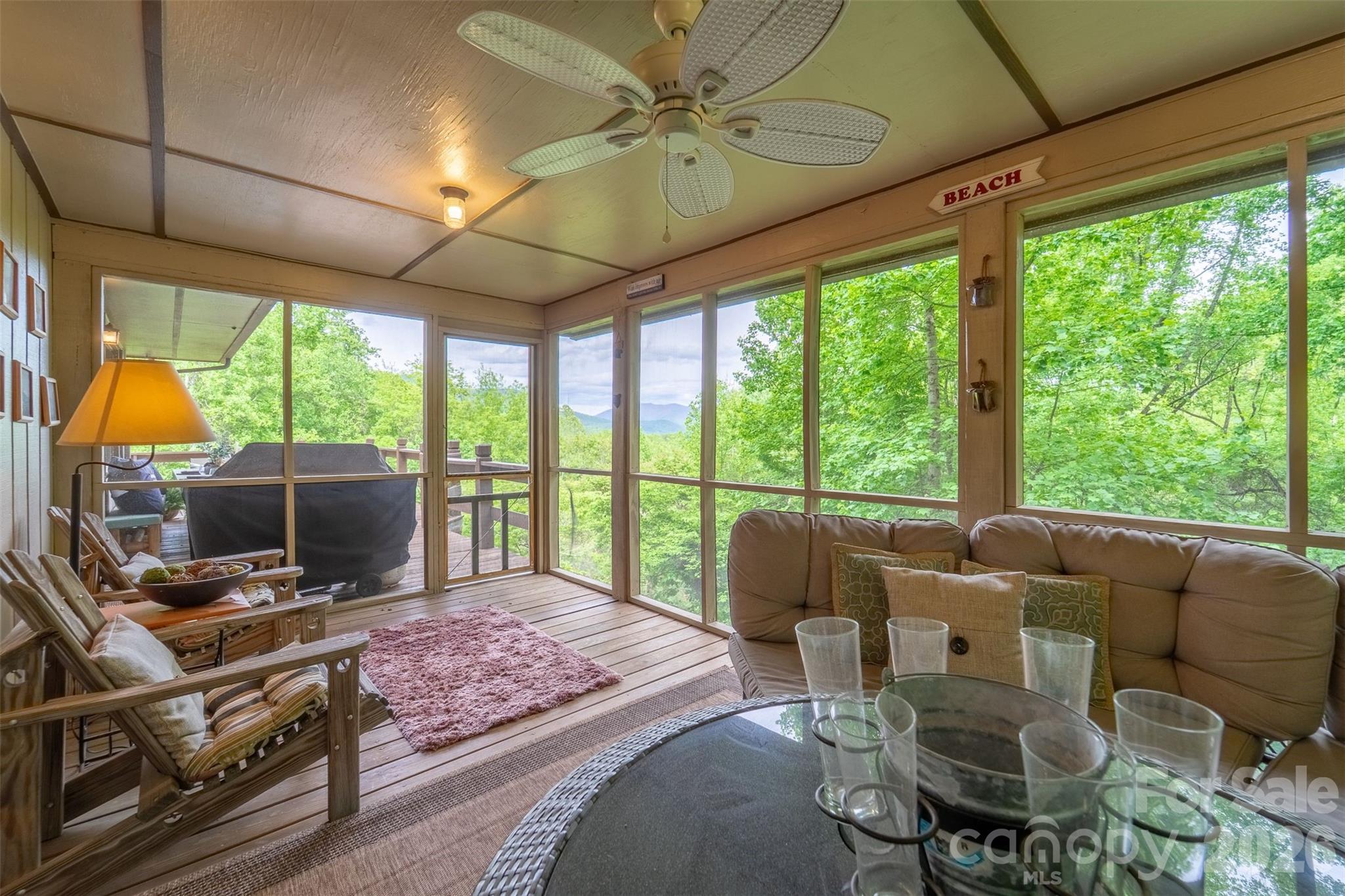 1413 Kitchens Branch Road Sylva, NC 28779 - Photo 29 of 46 a living room with furniture a flat screen tv and a floor to ceiling window