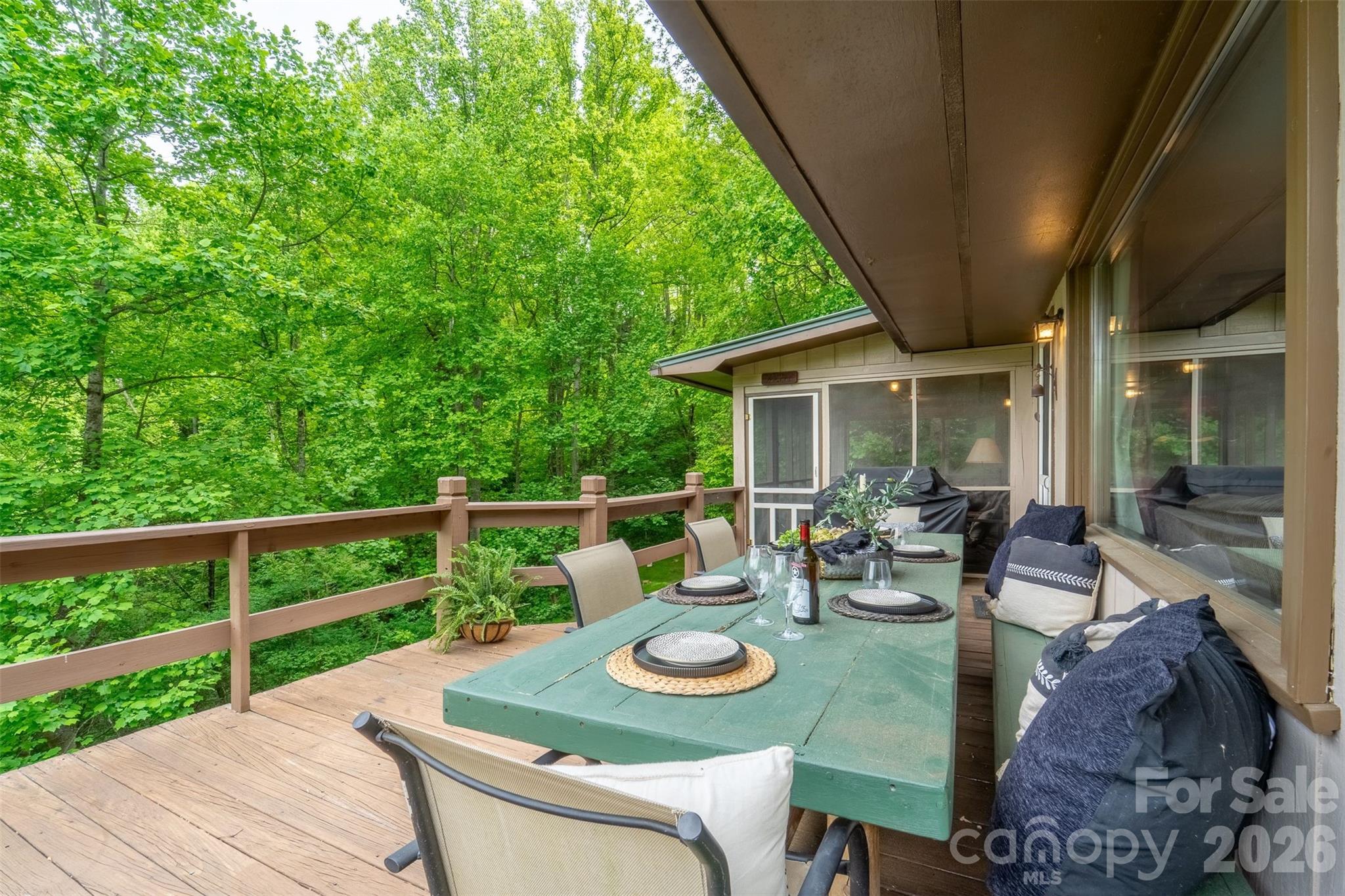 1413 Kitchens Branch Road Sylva, NC 28779 - Photo 32 of 46 a view of a patio with table and chairs and wooden floor