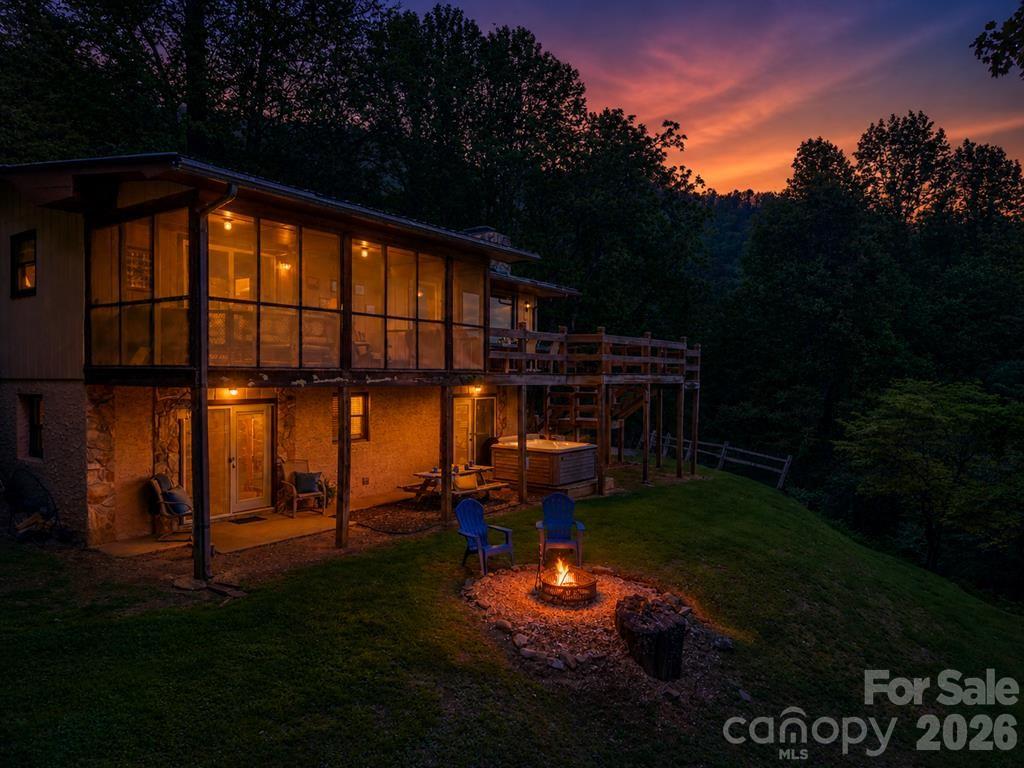 1413 Kitchens Branch Road Sylva, NC 28779 - Photo 34 of 46 a backyard of a house with table and chairs