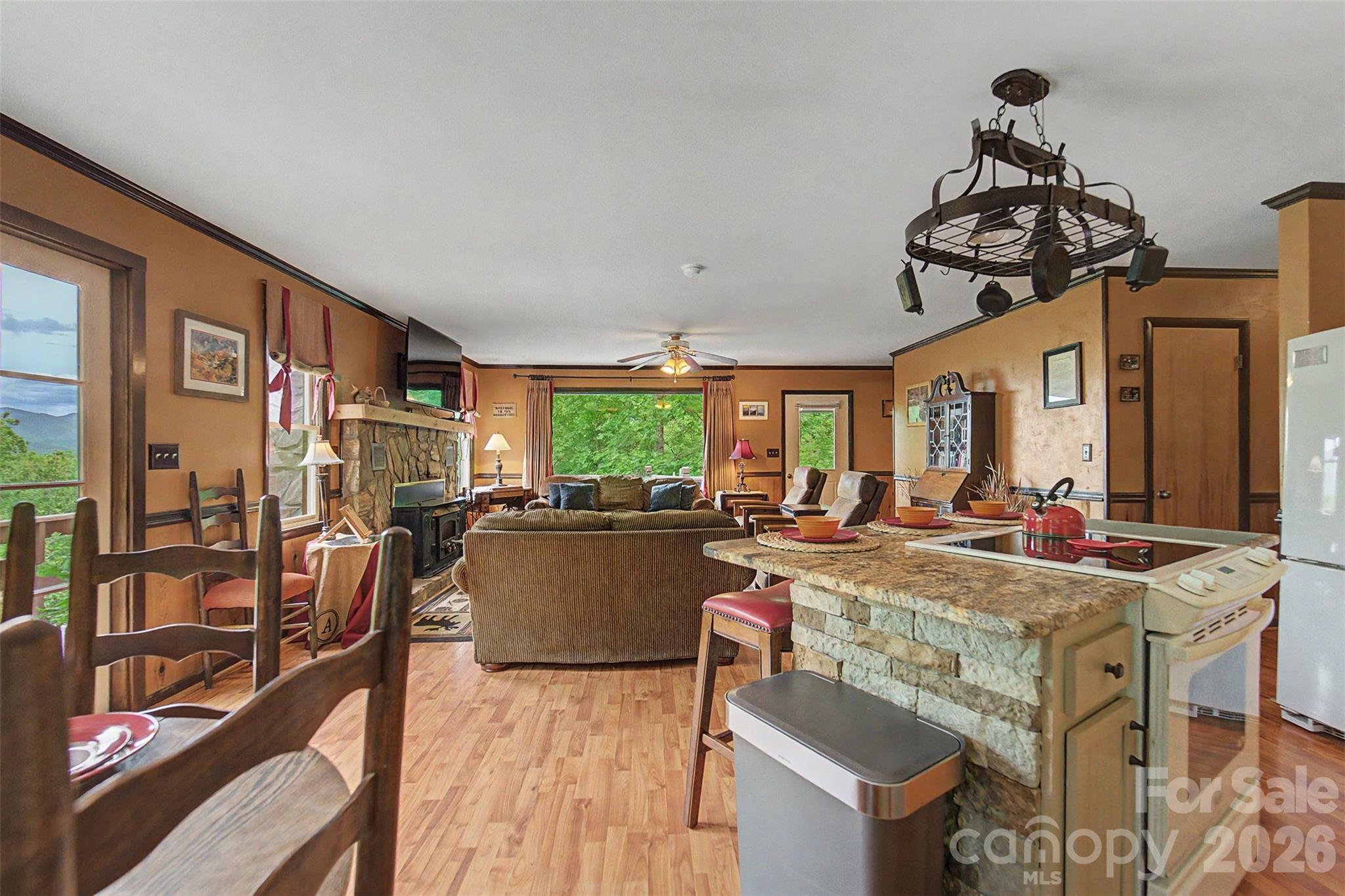 1413 Kitchens Branch Road Sylva, NC 28779 - Photo 5 of 46 a view of a dining room with furniture a chandelier and large windows