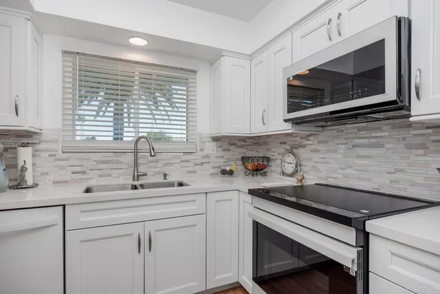 a view of a patio with table and chairs potted plants and a large window