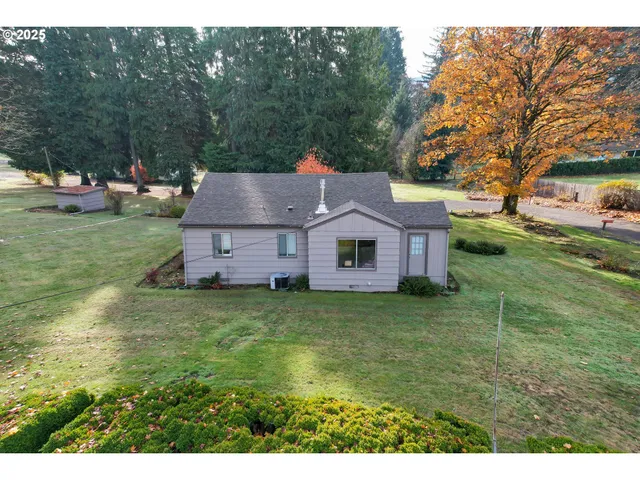 a aerial view of a house with a big yard plants and large trees