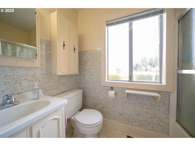 a bathroom with a sink a toilet and a window